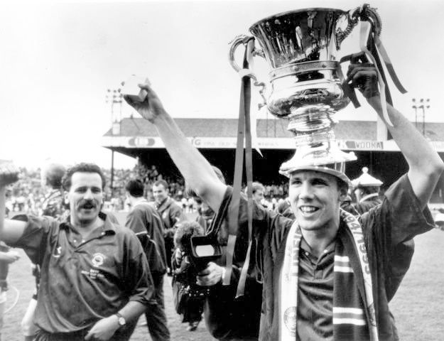 Linfield player Noel Bailie parades the championship trophy