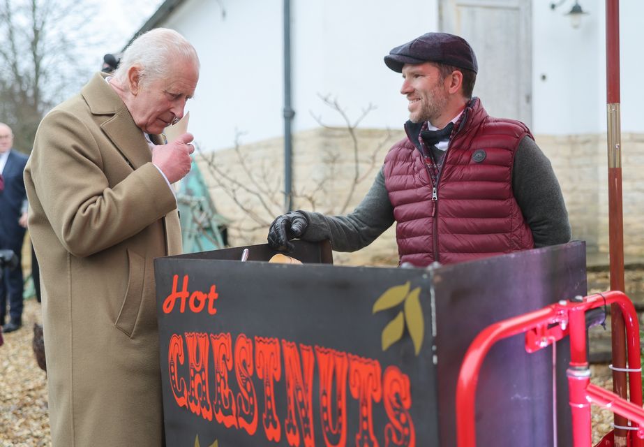 The King smells the roasted chestnuts handed to him by vendor Paul Venn (Chris Jackson/PA)