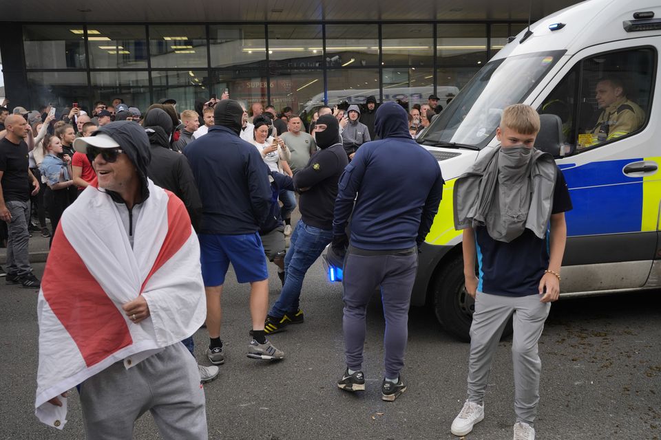 A man leans on a police van during an anti-immigration protest outside the Holiday Inn Express in Rotherham, South Yorkshire, on Sunday August 4 (Danny Lawson/PA)