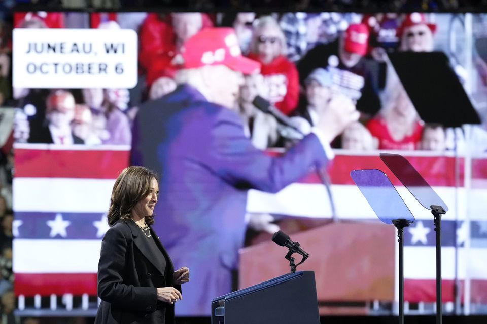 Vice President Kamala Harris speaks as an image of Donald Trump appears on screen (Jacquelyn Martin/AP)