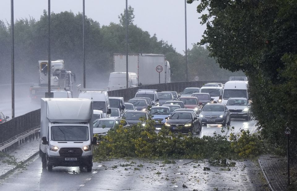 Vehicles negotiate debris from a tree on the North Circular in London (Nick Potts/PA)