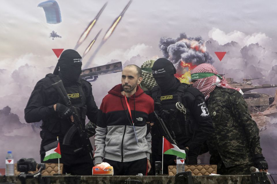 Israeli hostage Tal Shoham is escorted by Hamas fighters before being handed over to the Red Cross in Rafah, southern Gaza, on Saturday (Jehad Alshrafi/AP)