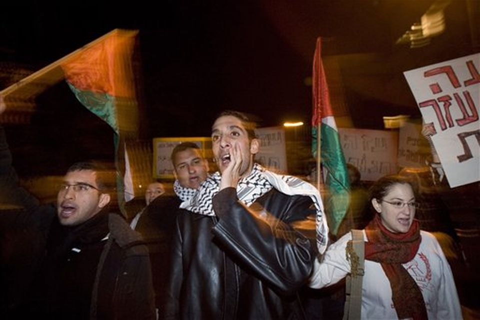 Israeli Arabs and left wing activists wave Palestinians flags during a protest against the Israeli strikes on the Gaza Strip in Tel Aviv, Israel, Saturday, Dec. 27, 2008. Israeli warplanes retaliating for rocket fire from the Gaza Strip pounded dozens of security compounds across the Hamas-ruled territory in unprecedented waves of airstrikes Saturday, killing more than 200 people and wounding nearly 400 in the single bloodiest day of fighting in years. (AP Photo/Ariel Schalit)