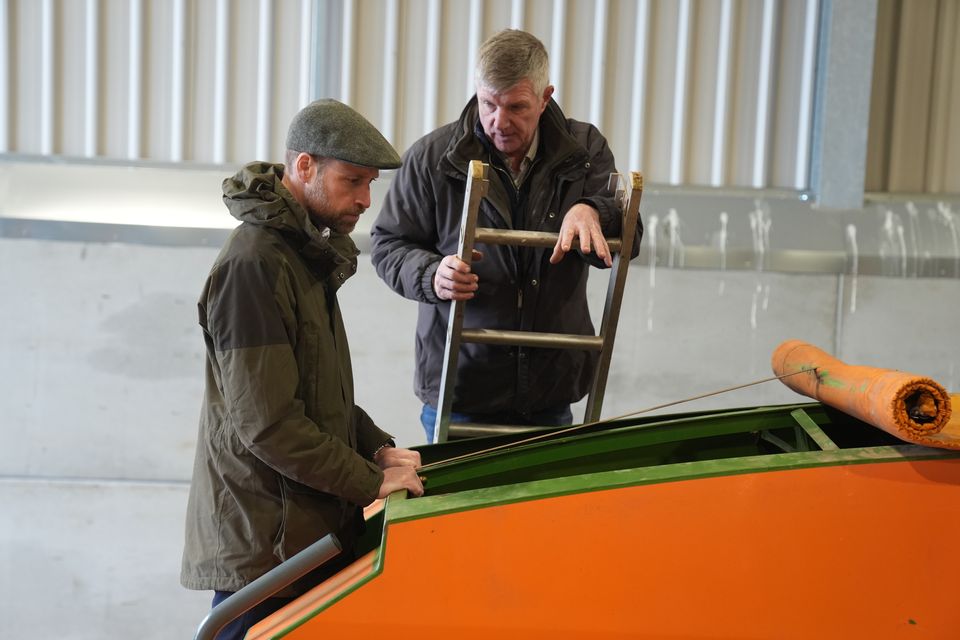 Farmer Phil Gorringe shows the Prince of Wales a seed drill machine (Jacob King/PA)