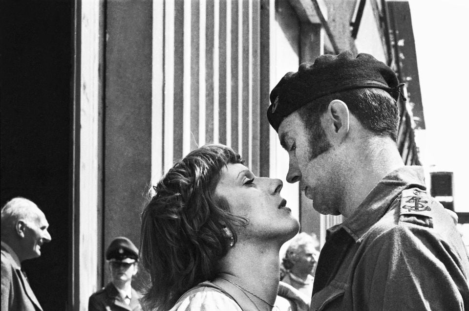 A couple lean in for a kiss as British troops are waved off at Southampton in 1982 (Mirrorpix/PA)