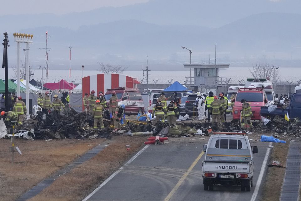 Rescue team members work at the site of a plane fire at Muan International Airport in Muan, South Korea (AP/Ahn Young-joon)