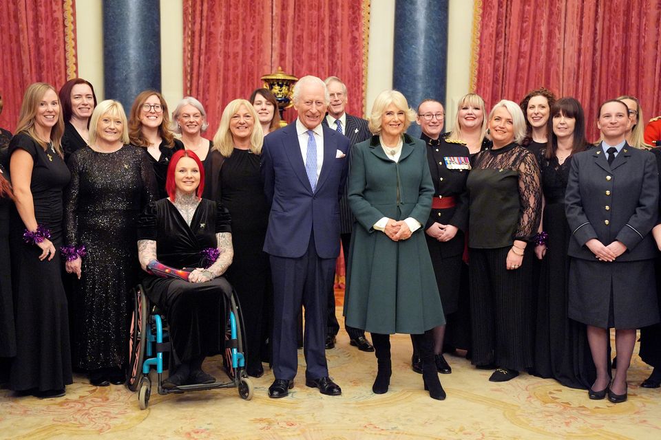 The Military Wives Choir pose for a photo with Charles and Camilla at Buckingham Palace (Yui Mok/PA)