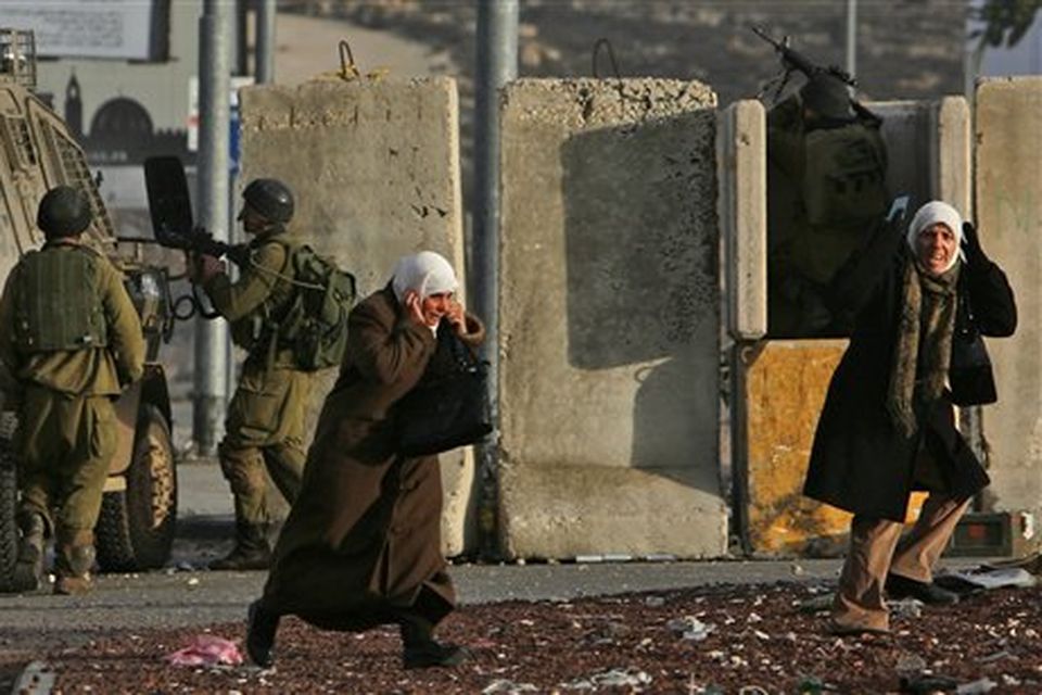 Palestinian women run away during clashes between Israeli soldiers and Palestinians, following a demonstration against the Israeli missiles strike on Gaza, at the Kalandia checkpoint between the West Bank city of Ramallah and Jerusalem Saturday, Dec. 27, 2008. Israeli warplanes attacked dozens of security compounds across Hamas-ruled Gaza on Saturday in unprecedented waves of air strikes. Gaza medics said at least 145 people were killed and more than 310 wounded in the single deadliest day in Gaza fighting in recent memory. (AP Photo/Muhammed Muheisen)