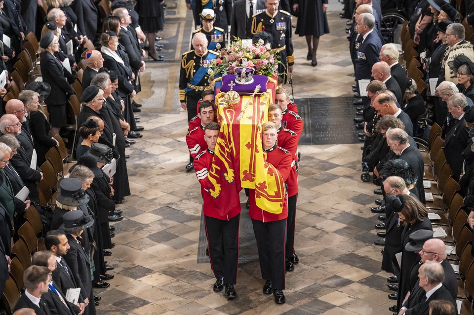 Elizabeth II’s coffin, draped in the Royal Standard with the Imperial State Crown and the Sovereign’s orb and sceptre, is carried out of Westminster Abbey after her state funeral (Danny Lawson/PA)