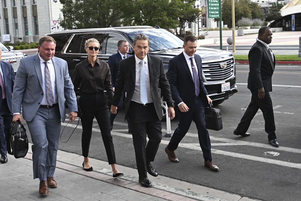 Lachlan Murdoch, centre, and his wife Sarah arrive at court in Reno (Andy Barron/AP)