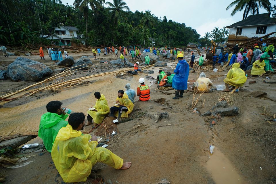 Rescuers break for food while looking for survivors after landslides hit hilly villages (AP Photo)