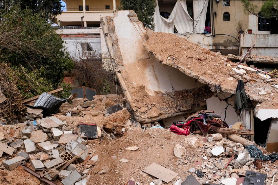 Displaced residents walk on the rubble of their destroyed house in Baalbek, eastern Lebanon (Hassan Ammar/AP)