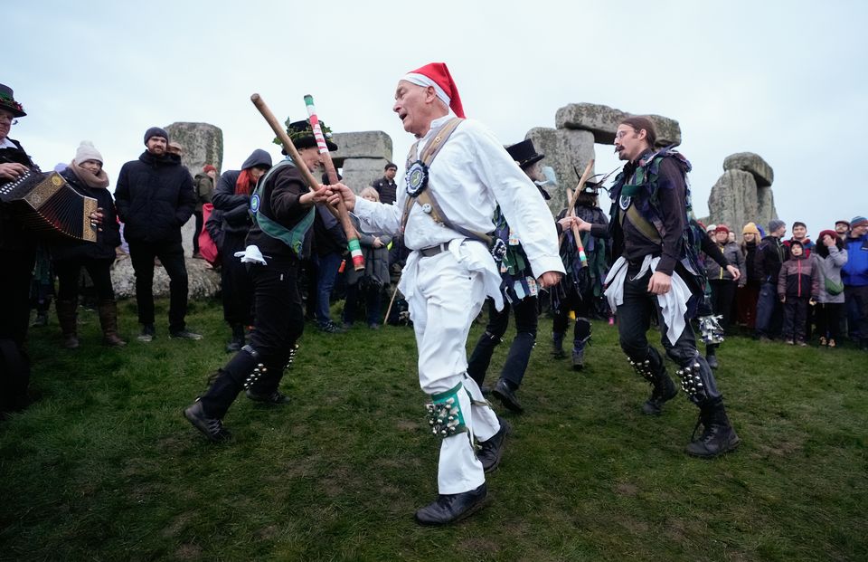 Morris dancers perform in front of the stones formation (Andrew Matthews/PA)