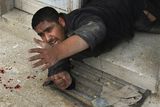 thumbnail: An injured Palestinian security force officer from Hamas crawls as he waits for assistance at the site of an Israeli missile strike at the security headquarters in Gaza City, Saturday, Dec. 27, 2008. Israeli warplanes retaliating for rocket fire from the Gaza Strip pounded dozens of security compounds across the Hamas-ruled territory in unprecedented waves of airstrikes Saturday, killing more than 200 people and wounding nearly 400 in the single bloodiest day of fighting in years. (AP Photo/Thaer Al-Hasani)