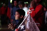 thumbnail: A boy gestures as he watches on TV the rescue operations at the San Jose mine to free 33 trapped miners in Copiapo, Chile, late Tuesday Oct. 12, 2010.  Thirty-three miners became trapped when the gold and copper mine collapsed on Aug. 5. (AP Photo/Dario Lopez-Mills)
