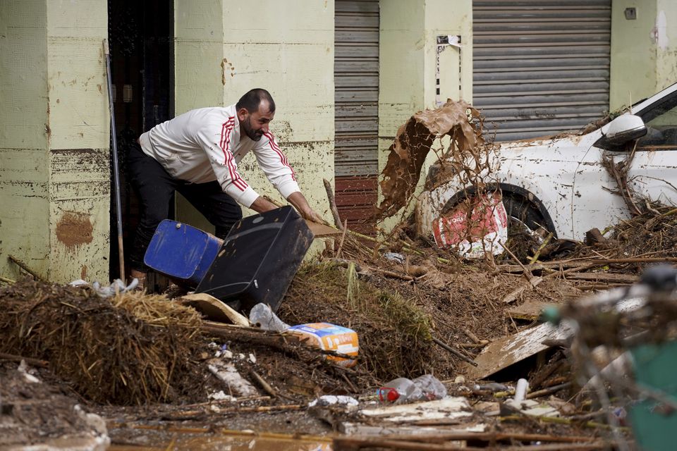 A man cleans his house affected by floods in Valencia (Alberto Saiz/AP)