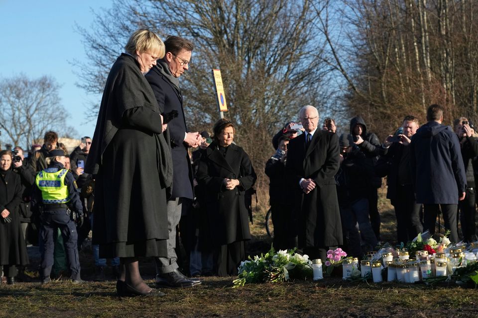 The Prime Minister of Sweden, Ulf Kristerson, and his wife, Birgitta Ed, place flowers in a monument near the scene of a shooting on the outskirts of Obebro, Sweden, on Wednesday, February 5, 2025. (Ap Photo/Sergei Grits )