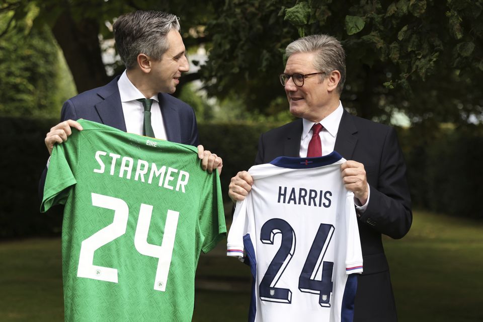 Taoiseach Simon Harris and Prime Minister Sir Keir Starmer hold up their respective national football teams’ shirts, with their names on their opposite teams’ shirts, at Farmleigh House (Peter Morrison/PA)