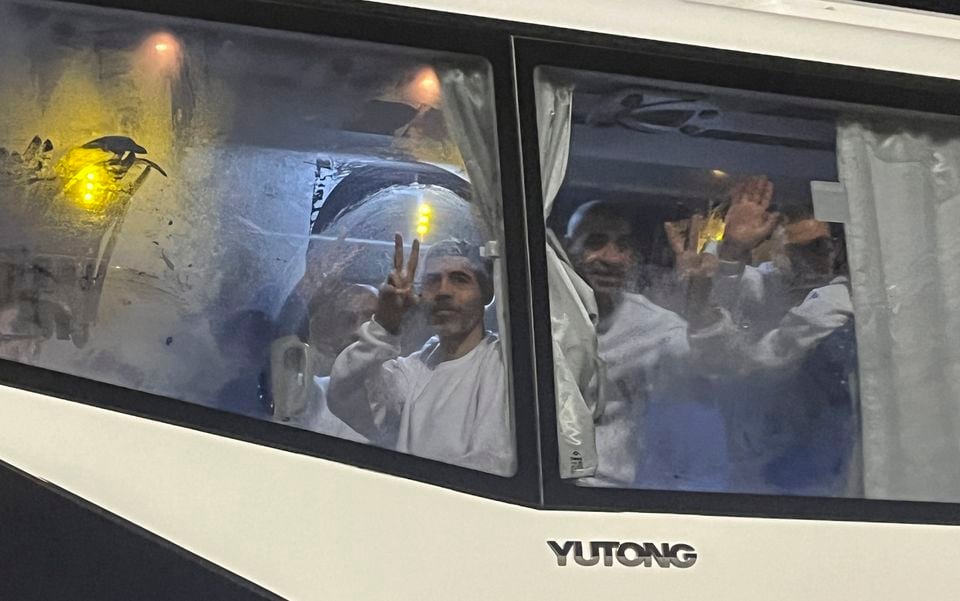 Palestinian prisoners wave after being released from an Israeli prison (Mohamed Arafat/AP)