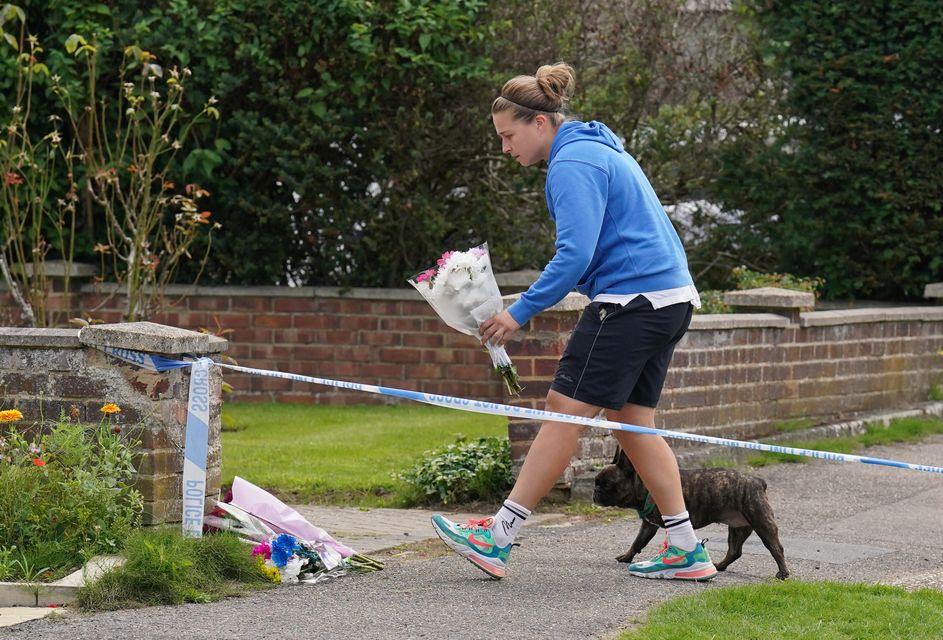 A person leaves flowers outside a property on Hammond Road in Woking (Jonathan Brady/PA)