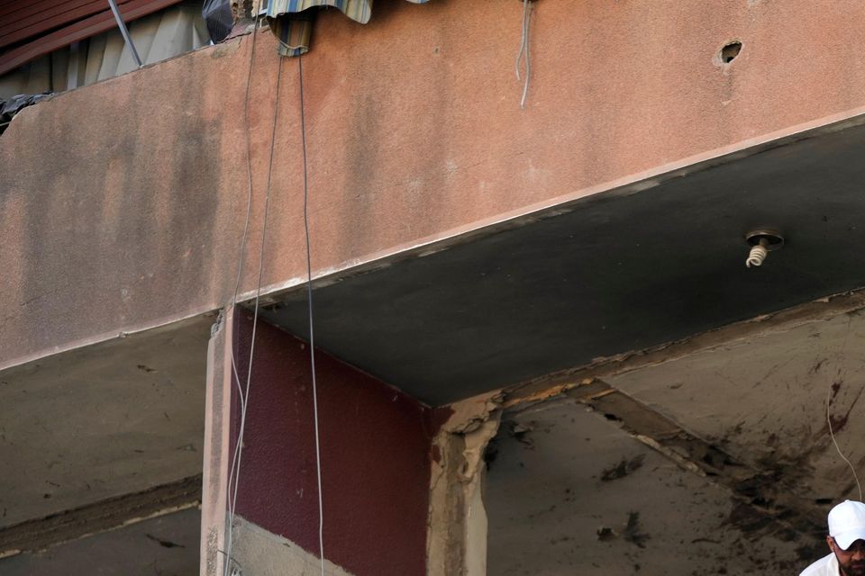 Residents and rescuers check a building that was hit by an Israeli airstrike in Beirut’s southern suburbs (Hassan Ammar/AP)