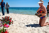 thumbnail: Holidaymakers react as people lay flowers on Marhaba beach, where 38 people were killed in a terrorist attack last Friday, on June 30, 2015 in Sousse, Tunisia. British police have been deployed to the area as part of one of the biggest counter terror operations since the London bombings on July 7, 2005. (Photo by Jeff J Mitchell/Getty Images)