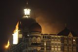 thumbnail: Smoke emerges from behind a dome on the Taj Hotel in Mumbai, India, Wednesday, Nov. 26, 2008. Teams of heavily armed gunmen stormed luxury hotels, a popular tourist attraction and a crowded train station in at least seven attacks in India's financial capital, killing at least 78 people and wounding at least 200, officials said. The gunmen were specifically targeting Britons and Americans, media reports said, and may be holding hostages. The gunmen also attacked police headquarters in south Mumbai, the area where most of the attacks, which began late Wednesday and continued into Thursday morning, took place.  (AP Photo/Gautam Singh)