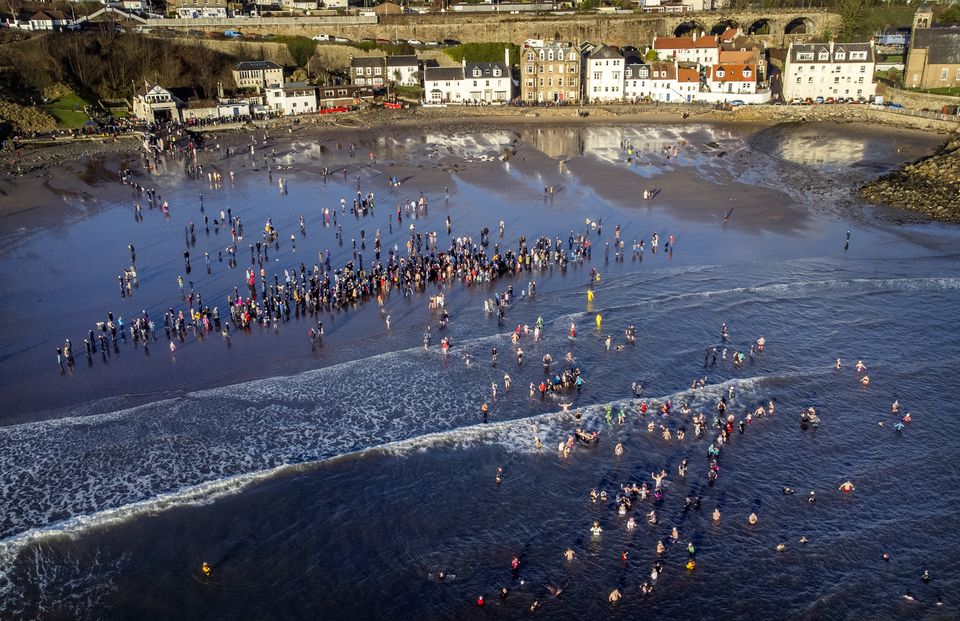 People take part in a loony dook dip in the Firth of Forth at Kinghorn, Fife, on the first day of 2024 (Jane Barlow/PA)