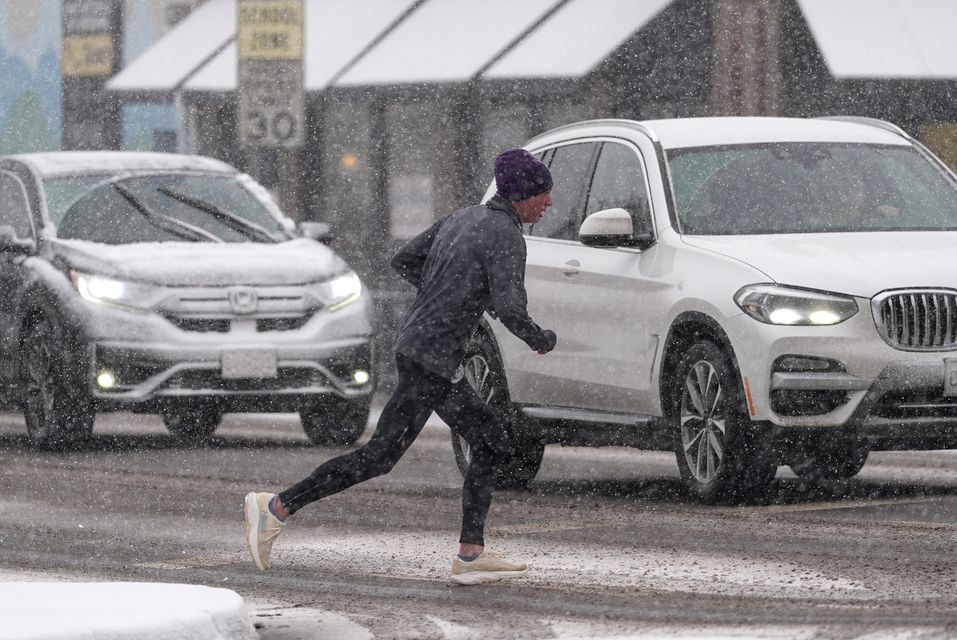 A runner contends with heavy snow in Colorado (David Zalubowski/AP)