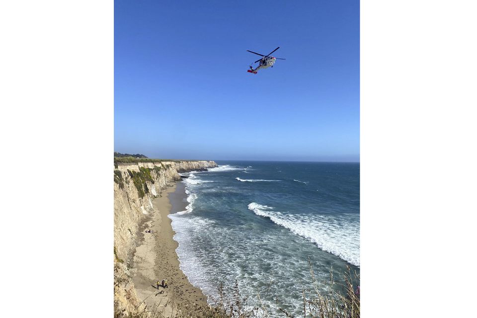 The scene of the rescue of a kite surfer on a beach under a cliff (Cal Fire CZU via AP)