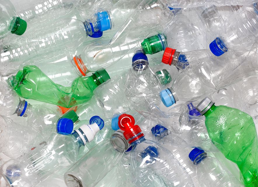 discarded used water bottles in recycling bin.  The lids can be recycled as well if reattached to the water bottle