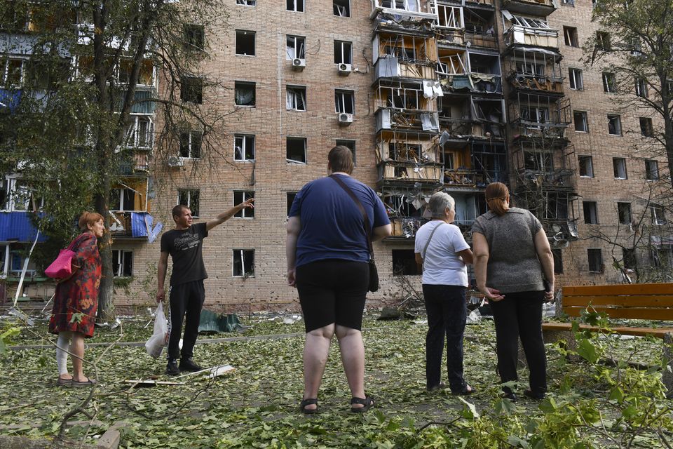 Residents of an apartment building damaged after Ukrainian shelling stand near the building in Kursk, Russia (AP)