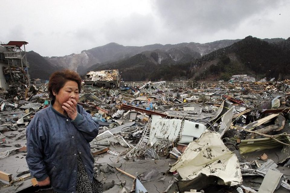 Reiko Miura, 68, cries as she looks for her sister's son at a tsunami-hit area in Otsuchi, northern Japan