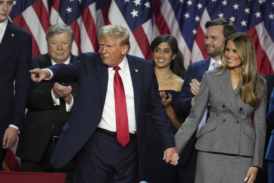 Donald Trump holds hands with former first lady Melania Trump after speaking to supporters in West Palm Beach (Lynne Sladky/AP)