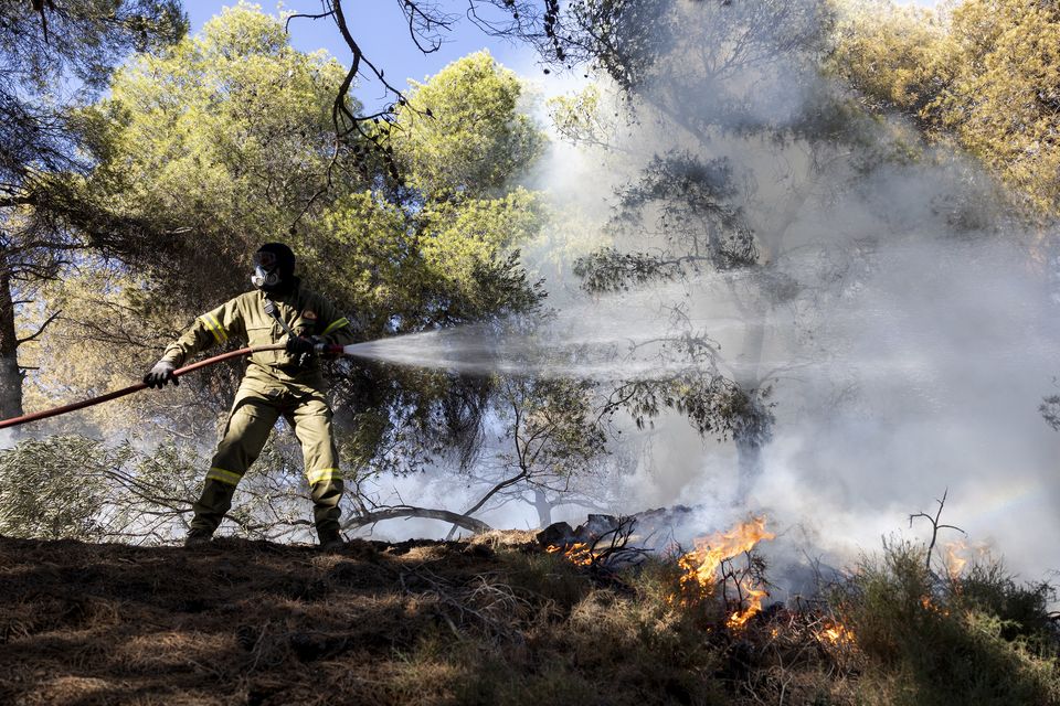 A firefighter struggles to extinguish a forest fire at Keratea area, southeast of Athens, Greece (Yorgos Karahalis/AP)