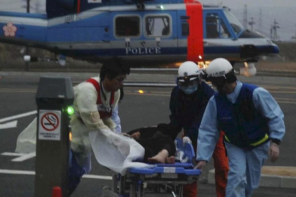An 80-year-old woman is carried on a stretcher to the Ishinomaki Red Cross Hospital after being rescued with a 16-year-old boy
