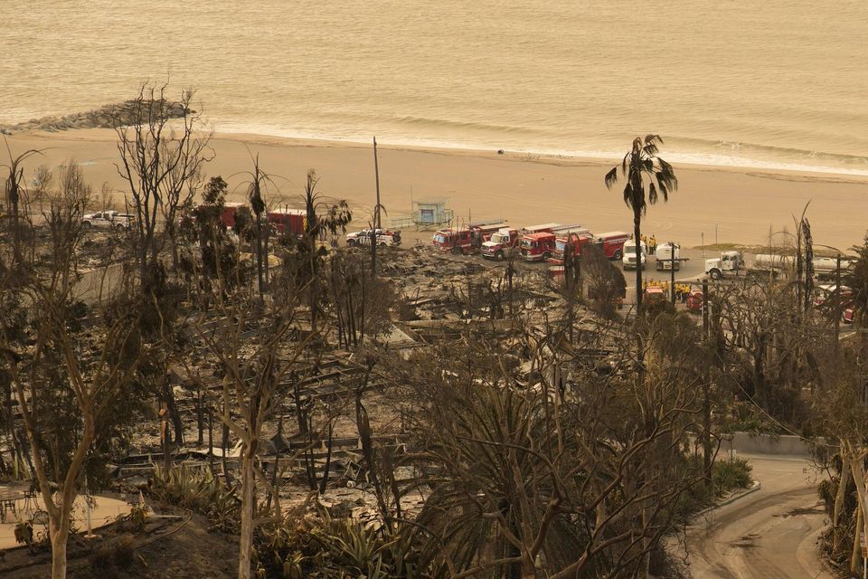 A person walks down a street in the aftermath of the Palisades Fire in the Pacific Palisades neighbourhood of Los Angeles (John Locher/AP)