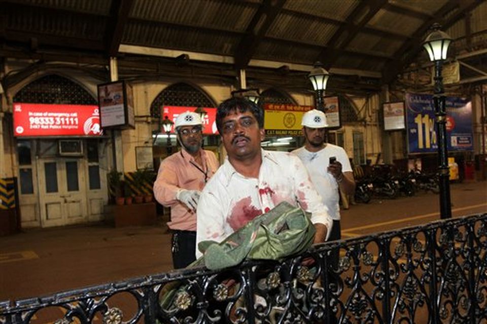 A man injured in firing leans on a railing in Mumbai, India, Wednesday, Nov. 26, 2008. Police say several people have been wounded in a series of attacks by terrorist gunmen at seven sites in Mumbai, including two luxury hotels.  A.N. Roy, a senior police officer, says police were battling the gunmen. (AP Photo)