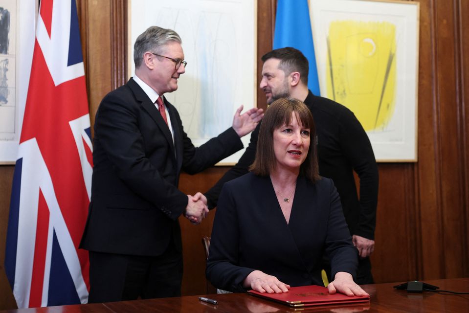 Rachel Reeves after signing the extraordinary revenue acceleration loans to Ukraine document as she holds a video conference meeting with Ukraine’s Finance Minister Sergii Marchenko, as Prime Minister Sir Keir Starmer and Ukrainian President Volodymyr Zelensky shake hands (Toby Melville/PA)