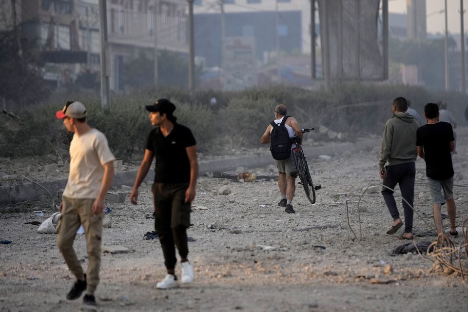 People walk on the debris of destroyed buildings in Dahiyeh, Beirut, Lebanon, after Israeli air strikes (Hussein Malla/AP)