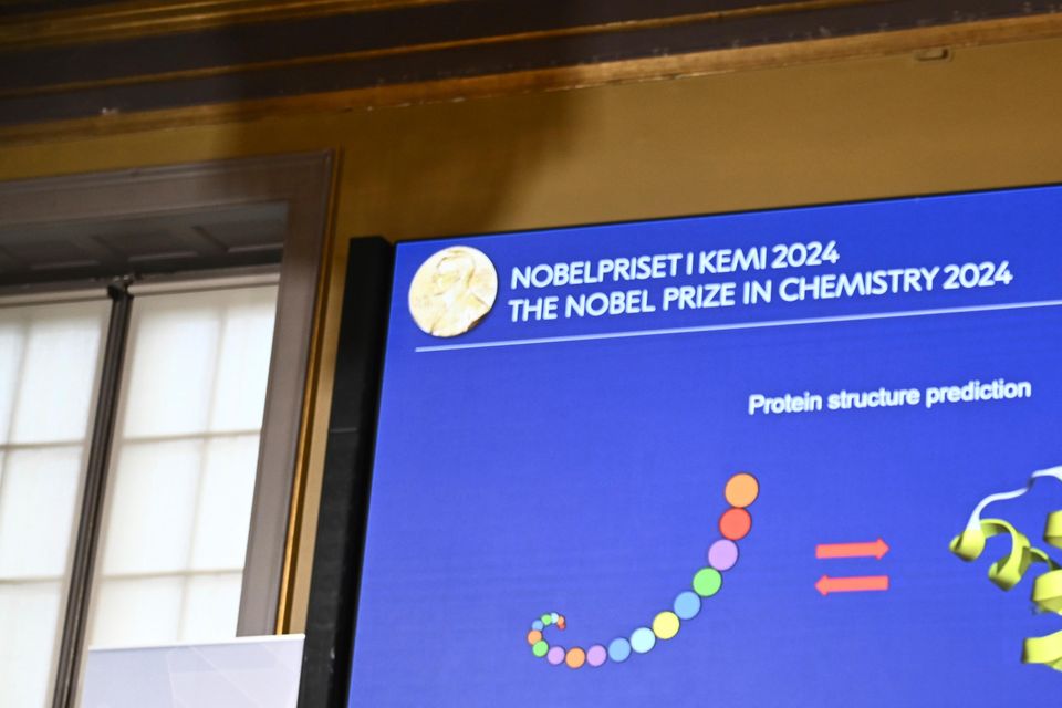 Johan Aqvist, right, of the Nobel Committee for Chemistry, explains the work of this year’s prize winners, David Baker, Demis Hassabi and John Jumper (Christine Olsson/AP)