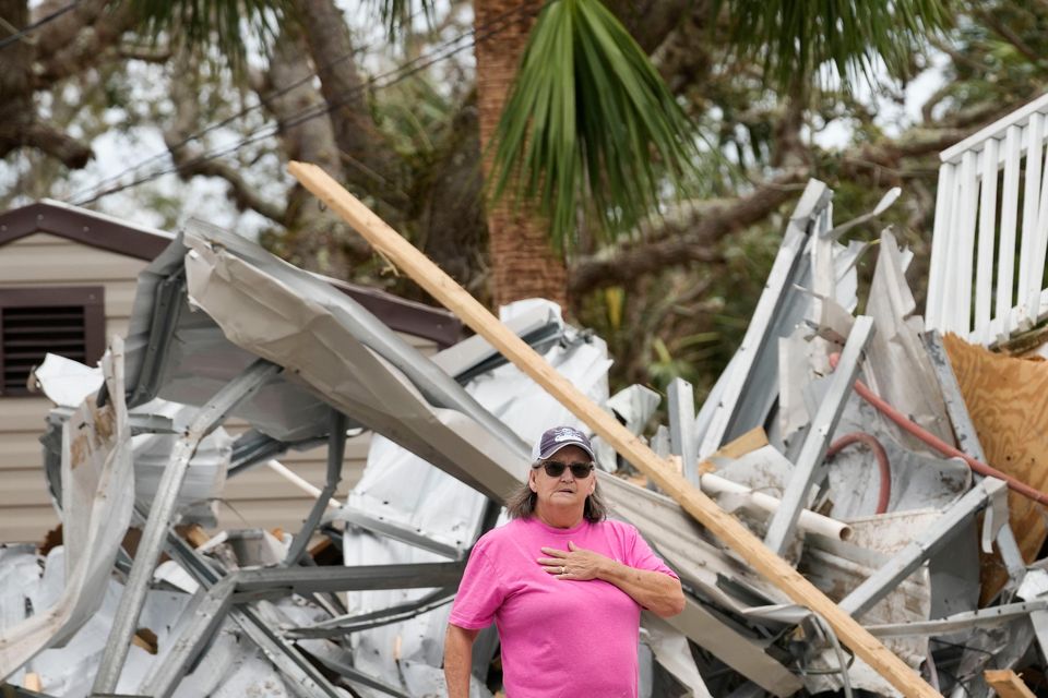 Frankie Johnson, left, talks with fellow resident Charlene Huggins, whose home was destroyed, amid the destruction in the aftermath of Hurricane Helene, in Horseshoe Beach, Florida (Gerald Herbert/AP)