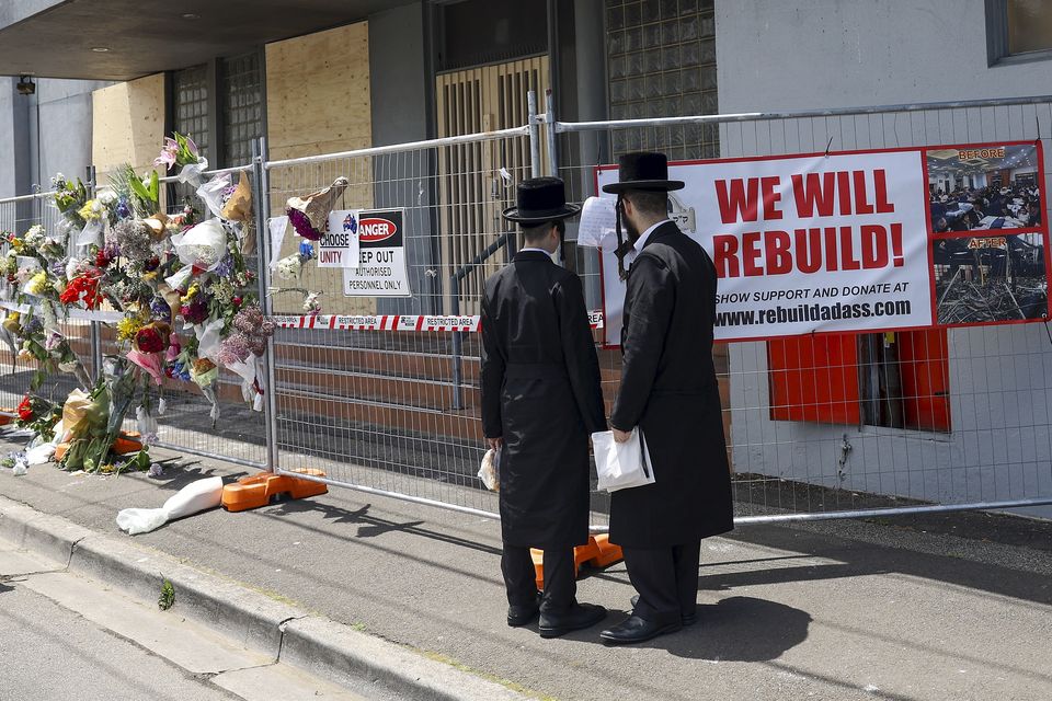 People gather outside the fire damaged Adass Israel Synagogue in Melbourne (Con Chronis/AAP Image via AP)