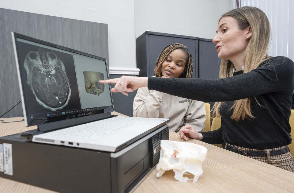 (l to r) Ruvimbo Kaviya and biomedical engineer Lisa Ferrie look at an MRI scan and 3D digital model of the tumour (Danny Lawson/PA)