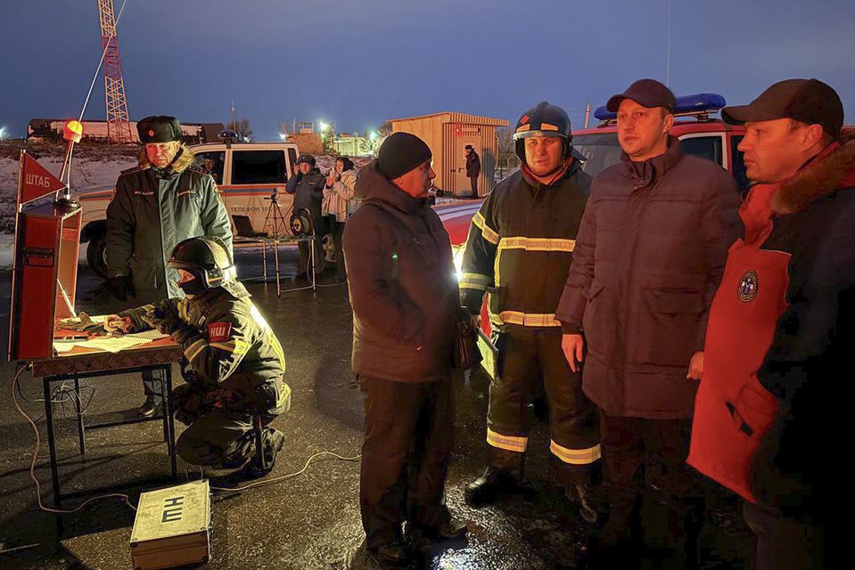 Governor of the Saratov region Roman Busargin, second right, speaks to firefighters at the industrial site damaged by Ukrainian drone attacks (Governor of the Saratov region Roman Busargin telegram channel/AP)