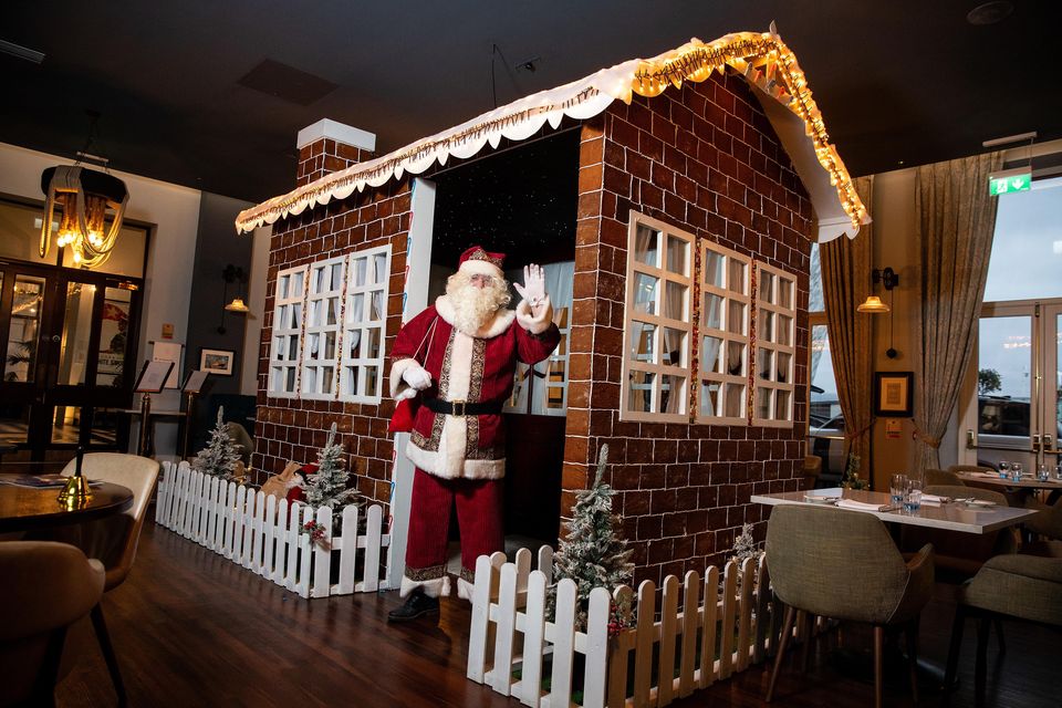 Santa outside the gingerbread house