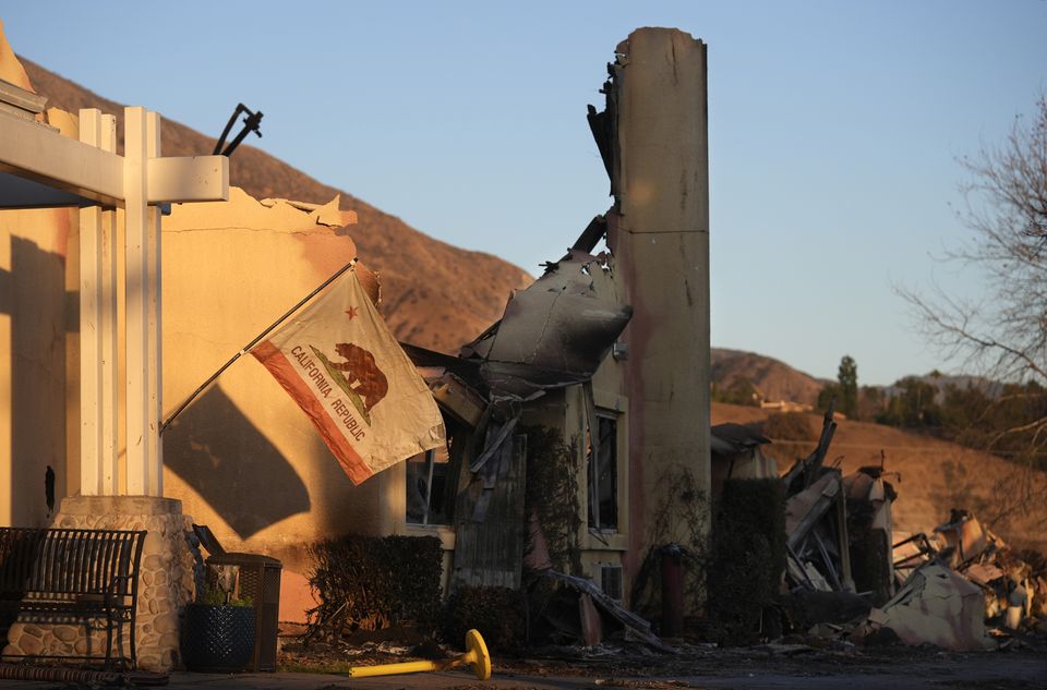 A California state flag hangs outside the charred remains of the Terraces at Park Marino assisted living facility in Pasadena, California (Chris Pizzello/AP)