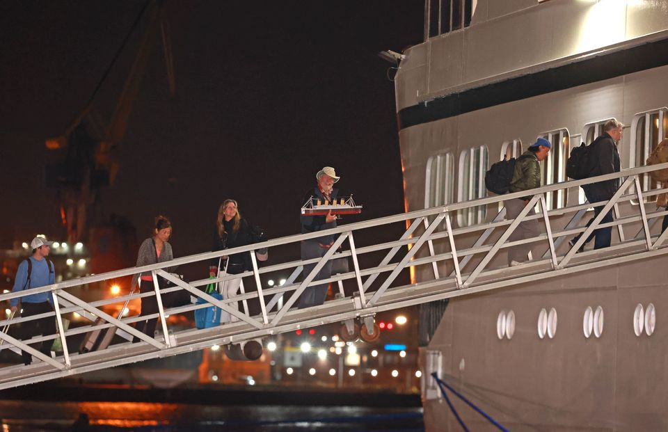 Passengers board the Villa Vie Odyssey cruise ship at Belfast Port’s Cruise Ship Terminal, after the luxury cruise ship became marooned in Belfast for four months due to unexpected repair works (Liam McBurney/PA)