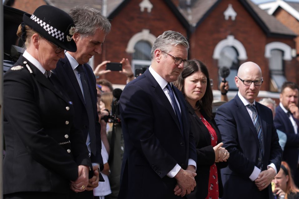 Prime Minister Sir Keir Starmer (centre) observes the floral tributes near the scene in Hart Street, Southport (James Speakman/PA)