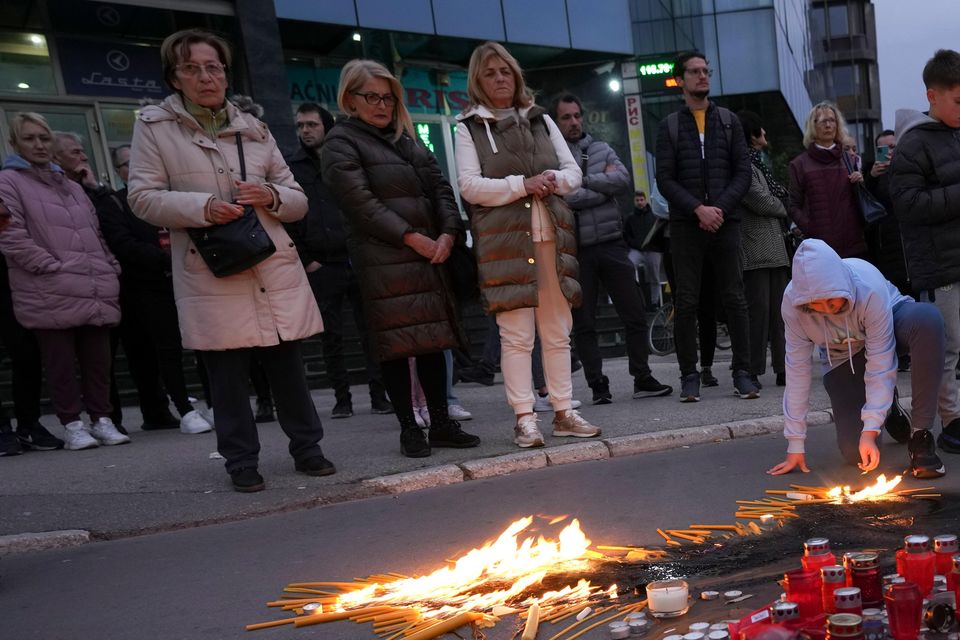 People light candles for the victims of an outdoor roof collapse at a train station in Novi Sad, Serbia (AP Photo/Darko Vojinovic)